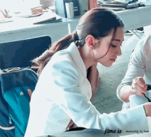 a woman in a white jacket sits at a table with the words jane is beautiful is jane written below her