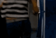 a woman in a striped shirt is walking out of an airplane door .