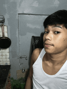 a man wearing a white tank top has a mustache
