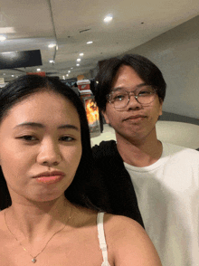 a man and a woman pose for a photo in a mall