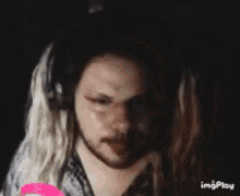 a man with long blonde hair and a beard is wearing headphones