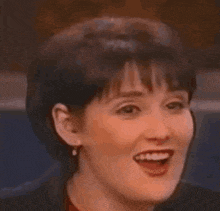 a close up of a woman smiling with her mouth open .