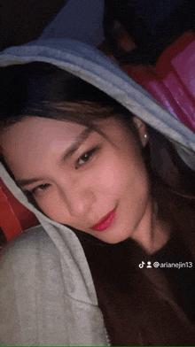 a woman is laying on a bed with a blanket over her head and the hashtag arianeight is on the bottom right
