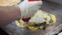 a person is cooking food on a griddle and the griddle is made in animonica