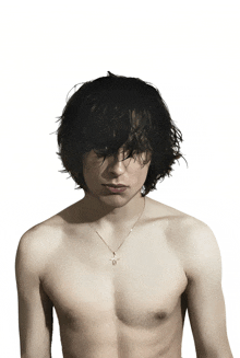 a man without a shirt is wearing a necklace that has the letter b on it