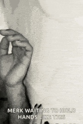 a black and white photo of a person 's hand holding something .