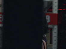 a woman is standing in front of a red sign that says 2