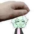a hand is putting a cartoon character on top of a person 's head .