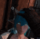 a screenshot of a video game shows a woman with blue hair and a necklace