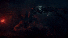 a monster is fighting another monster in a dark scene
