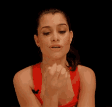 a woman in a red top is clapping her hands