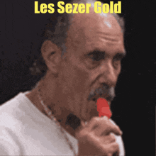 a man is singing into a microphone with the words les sezer gold written above him