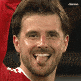 a close up of a man 's face with his tongue sticking out and the words canirove below it