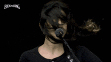 a woman singing into a microphone with rock the ring written on the bottom