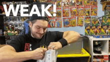 a man in front of a wall of x-men toys with the word weak above him