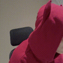 a close up of a person wearing a red hoodie with horns on the hood .