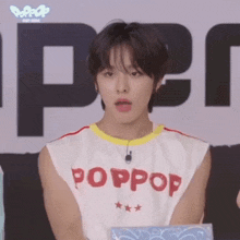 a young man wearing a white tank top that says poppop on it