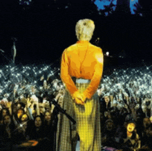 a woman in an orange shirt stands in front of a crowd of people