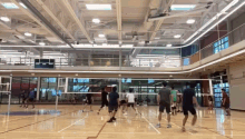 a group of young men are playing volleyball in a gym