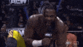 a wrestler is kneeling down in front of a microphone with the words minutes written on the bottom