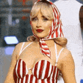 a woman wearing a red and white striped dress and a head scarf