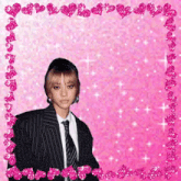 a woman in a suit and tie is surrounded by pink hearts and sparkles
