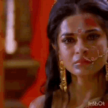 a close up of a woman 's face with a bindi on her forehead .