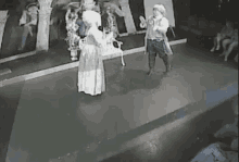 a man and a woman are dancing on a stage in a room .