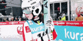a woman wearing a uvex helmet and goggles holds a pole
