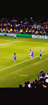 a soccer game is being played in front of a large heineken sign