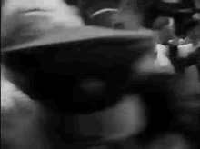 a black and white photo of a person wearing a hat and sunglasses .
