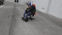 a man sitting in an office chair with a hat on his head that says ' i 'm a wizard '