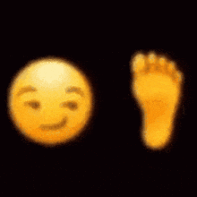 a yellow smiley face and a yellow foot on a black background .