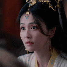 a close up of a woman 's face wearing a crown and earrings