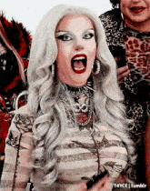 a woman with white hair and red lips is making a funny face