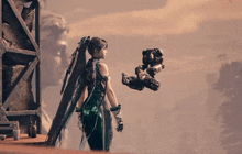 a woman in a green dress is holding a robot arm