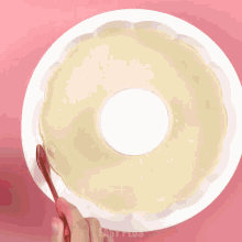 a person is pouring strawberry sauce into a white cake
