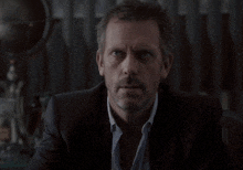 a man in a suit has his hand on his face