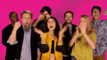 a girl in a yellow jacket is surrounded by other people