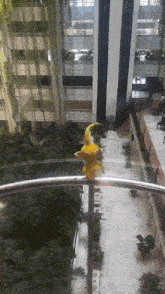 a yellow statue of a bird is sitting on a railing in a building