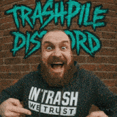 a man with a beard is wearing a hoodie that says in trash we trust
