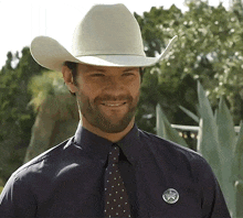 a man wearing a cowboy hat and a texas sheriff 's badge