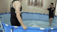 a man wearing a tank top that says mpd stands in a pool