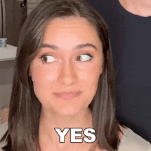 a close up of a woman 's face with the word yes on it