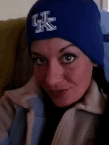 a woman wearing a blue hat with a white letter k on it