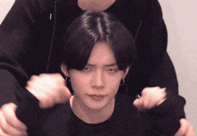 a man is holding another man 's head with his hands