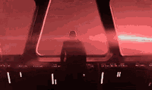 a man is standing on a bridge with a red light behind him .