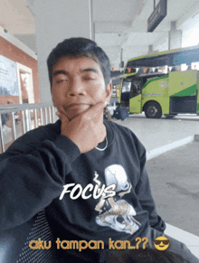 a man wearing a black sweatshirt that says focus on it