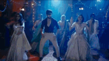 a man is dancing with a group of women in a dark room .