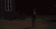 a person standing in front of a dark building